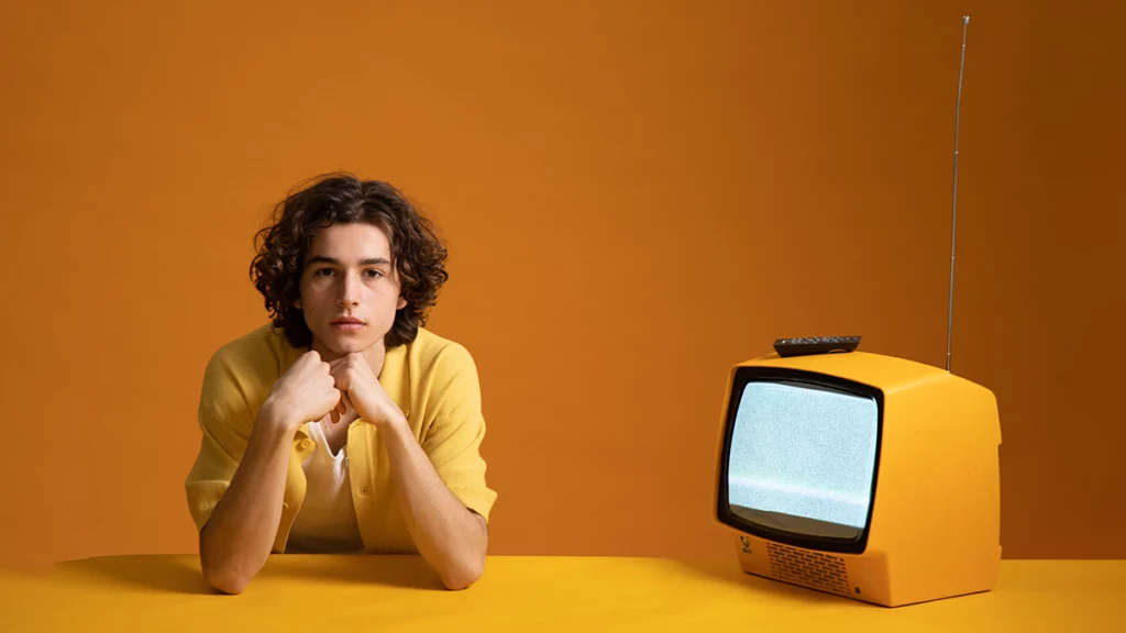 Person sitting with TV beside